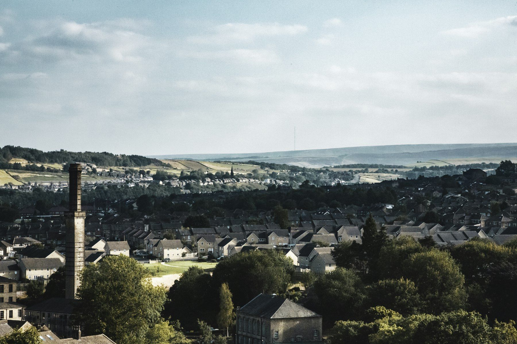 A Yorkshire mill chimney above a valley of stone terraces
