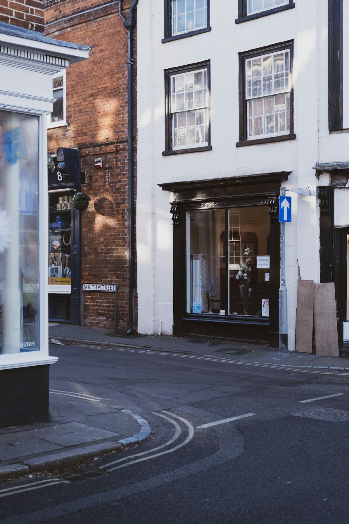 A vacant corner shopfront on a brick high street